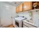 Well-lit laundry room with a utility sink, washer, dryer, and ample cabinet space for storage at 127 Mauve St, Henderson, NV 89012