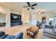 Open-concept living room featuring tile floors, neutral paint, ceiling fans, and a large TV at 127 Mauve St, Henderson, NV 89012