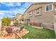 Spacious backyard featuring artificial turf, pond, outdoor kitchen, and mature landscaping at 1324 Spice Ridge Ct, Henderson, NV 89012
