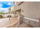 Outdoor kitchen with built-in stainless steel BBQ and stone counters, covered patio in background at 1324 Spice Ridge Ct, Henderson, NV 89012