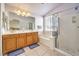 Well-lit bathroom with dual sinks, soaking tub, walk-in shower, and a window at 1324 Spice Ridge Ct, Henderson, NV 89012