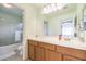 Bright bathroom featuring a large mirror, vanity with storage, and tub with shower at 1324 Spice Ridge Ct, Henderson, NV 89012