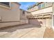 Spacious driveway leading to a garage, adjacent to a home with a neutral color palette and desert landscaping at 1324 Spice Ridge Ct, Henderson, NV 89012