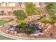 Backyard pond with a waterfall feature, lush plants and fish at 1324 Spice Ridge Ct, Henderson, NV 89012