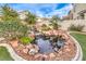 Picturesque backyard pond with stone accents, waterfall and mature plants at 1324 Spice Ridge Ct, Henderson, NV 89012
