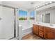 Bathroom with wooden cabinets, dual sinks, and a shower over tub at 16 Goldleaf Falls Ave, North Las Vegas, NV 89031