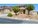 Charming two-story home with tan stucco, desert landscaping, and a welcoming front entrance at 16 Goldleaf Falls Ave, North Las Vegas, NV 89031
