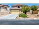 Inviting two-story home featuring a yellow two-car garage and well-maintained landscaping at 16 Goldleaf Falls Ave, North Las Vegas, NV 89031