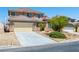 Well-maintained tan two-story home with a two-car garage, desert landscaping, and tiled roof at 16 Goldleaf Falls Ave, North Las Vegas, NV 89031