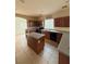 Open kitchen boasts dark wood cabinetry, an island, and stainless steel appliances at 16 Goldleaf Falls Ave, North Las Vegas, NV 89031