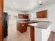 Bright kitchen features wood cabinets, speckled countertops, tile floors, and a kitchen island at 16 Goldleaf Falls Ave, North Las Vegas, NV 89031
