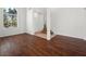 Bright living room with hardwood floors, large window, and view of the staircase and entry at 16 Goldleaf Falls Ave, North Las Vegas, NV 89031