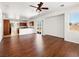 Open-concept living area with hardwood floors, ceiling fan, and access to the kitchen and patio at 16 Goldleaf Falls Ave, North Las Vegas, NV 89031