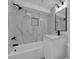 Modern bathroom featuring marble-style tile, sleek black fixtures, and a tub with shower at 1800 Atlantic St, Las Vegas, NV 89104