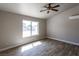 Bright bedroom features wood-look tile floors, ceiling fan, and natural light from the large window at 208 W Alma St, Overton, NV 89040