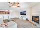 Carpeted living room featuring a fireplace, ceiling fan, and access to an open kitchen with breakfast bar at 2451 N Rainbow Blvd # 2131, Las Vegas, NV 89108
