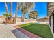 Relaxing backyard featuring mature trees, synthetic grass lawn, and desert landscaping at 2529 Indian Sage Way, Las Vegas, NV 89108