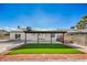 Home backyard featuring synthetic grass, desert landscaping and covered patio with solar panels at 2529 Indian Sage Way, Las Vegas, NV 89108