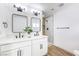 Bathroom featuring double sink vanity with black hardware, modern lighting, and tiled shower at 2529 Indian Sage Way, Las Vegas, NV 89108