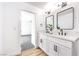 Bright bathroom with double vanity, two modern mirrors, and a door to the bedroom at 2529 Indian Sage Way, Las Vegas, NV 89108
