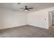 A cozy carpeted bedroom features a ceiling fan and access to another room at 2529 Indian Sage Way, Las Vegas, NV 89108