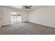Bright bedroom featuring modern ceiling fan, sliding glass door, and plush gray carpeting at 2529 Indian Sage Way, Las Vegas, NV 89108