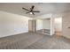 Carpeted bedroom boasts a ceiling fan, mirrored closet doors, and doorway to an ensuite bathroom at 2529 Indian Sage Way, Las Vegas, NV 89108