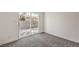 A clean carpeted bedroom featuring a sliding glass door for natural light and outdoor access at 2529 Indian Sage Way, Las Vegas, NV 89108