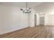 Bright dining area with contemporary chandelier, wood-look floors, white walls, and entry to the front door at 2529 Indian Sage Way, Las Vegas, NV 89108
