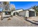 Single-story home with modern desert landscaping, an arched entry, and a black garage door at 2529 Indian Sage Way, Las Vegas, NV 89108