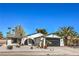 Well-maintained single-story home with a black garage door, desert landscaping, and mature trees at 2529 Indian Sage Way, Las Vegas, NV 89108