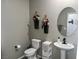 Powder room with round mirror, pedestal sink and modern faucet at 2585 Amazing Meadows Ave # 1007, North Las Vegas, NV 89031