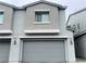 Two-story townhome featuring a gray exterior and a two-car garage at 2585 Amazing Meadows Ave # 1007, North Las Vegas, NV 89031