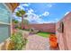 Landscaped backyard with brick pavers, greenery, and a privacy wall at 2601 Bechamel Pl, Henderson, NV 89044