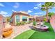 Manicured backyard with brick pavers, lush plants, and privacy walls at 2601 Bechamel Pl, Henderson, NV 89044