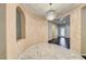 Elegant dining area with marble floors, arched niche, and modern chandelier at 2601 Bechamel Pl, Henderson, NV 89044