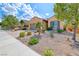 Landscaped front yard featuring drought-resistant plants, rock beds, and mature trees at 2601 Bechamel Pl, Henderson, NV 89044