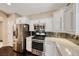 Well-equipped kitchen with stainless steel appliances, granite countertops, and a tile backsplash at 2601 Bechamel Pl, Henderson, NV 89044