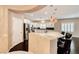 Modern kitchen with stainless steel appliances, mosaic backsplash, white cabinets, and hardwood floors at 2601 Bechamel Pl, Henderson, NV 89044