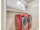 Laundry room featuring white cabinets above a modern, stacked washer and dryer at 2601 Bechamel Pl, Henderson, NV 89044