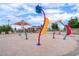 Image depicts a colorful splash pad area, perfect for Gathering fun with shade structures and seating nearby at 2601 Bechamel Pl, Henderson, NV 89044