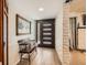 Inviting entryway featuring a modern door, wood flooring, and a bench beneath a charming painting at 2748 Heritage Cir, Las Vegas, NV 89121