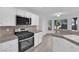 Modern kitchen with stainless steel appliances, granite countertops, and bright white cabinets with backyard views at 2808 Deep Water Cir, Las Vegas, NV 89117