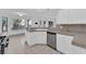 Well-lit kitchen featuring white cabinets, stainless steel dishwasher, and a view of the backyard through multiple windows at 2808 Deep Water Cir, Las Vegas, NV 89117
