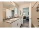 Bright bathroom featuring granite counters, white cabinetry, a sink, and a shower at 2845 Copper Wind Ln # 4, Las Vegas, NV 89183