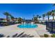Enjoy this outdoor community pool surrounded by palm trees, umbrellas, and lounge chairs on a sunny day at 2845 Copper Wind Ln # 4, Las Vegas, NV 89183