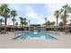 Resort-style community pool surrounded by lush palm trees and comfortable lounge chairs at 2845 Copper Wind Ln # 4, Las Vegas, NV 89183