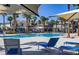 Resort-style pool with lounge chairs and umbrellas amid a lush landscape of palm trees at 2845 Copper Wind Ln # 4, Las Vegas, NV 89183