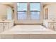 Modern bathroom with a large soaking tub, dual sinks, and expansive mirrors providing natural light at 3008 Barrett Springs Ave, Henderson, NV 89044