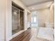 Elegant bathroom with a glass-enclosed shower, soaking tub, and doorway to the adjacent bedroom at 3008 Barrett Springs Ave, Henderson, NV 89044